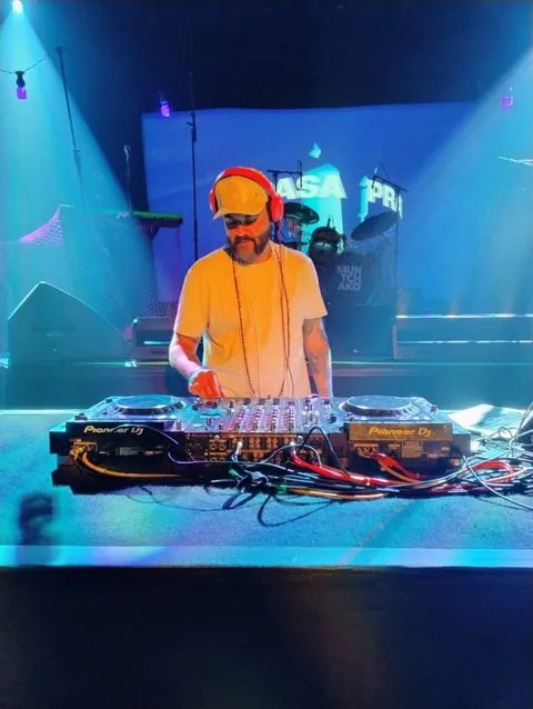DJ Rodrigo Miranda tocando em controladora Pioneer com luzes azuis